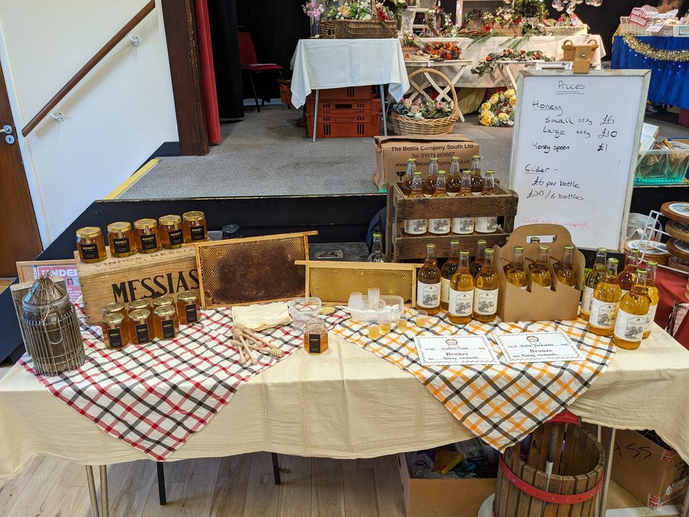An early Kilnside market table in 2023 with jars of honey, honeycomb frames and a few bottles of cider